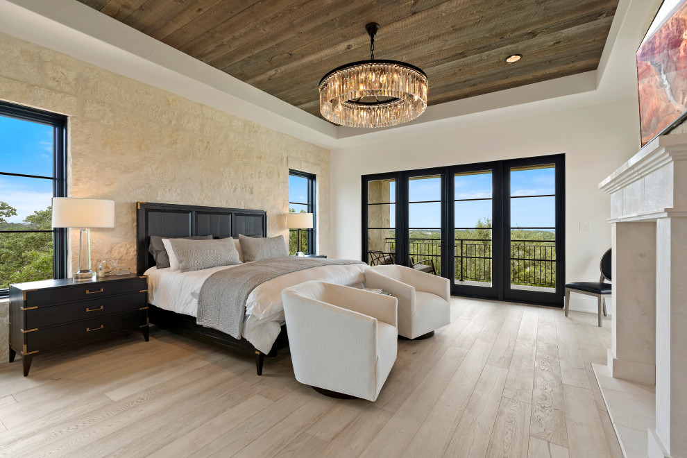 Foto de dormitorio principal extra grande con paredes blancas, suelo de madera clara, todas las chimeneas, madera y ladrillo