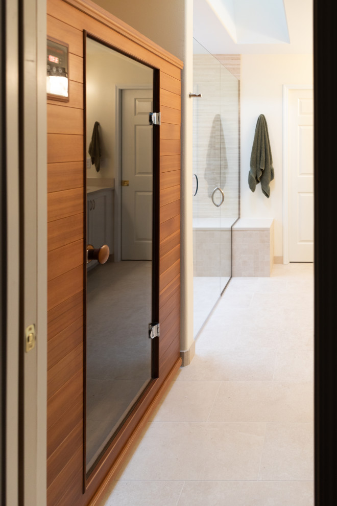 This is an example of a traditional sauna bathroom in Seattle with shaker cabinets, white cabinets, a built-in shower, a bidet, beige tiles, porcelain tiles, beige walls, porcelain flooring, a submerged sink, engineered stone worktops, beige floors, a hinged door, beige worktops, a shower bench, double sinks and a built in vanity unit.