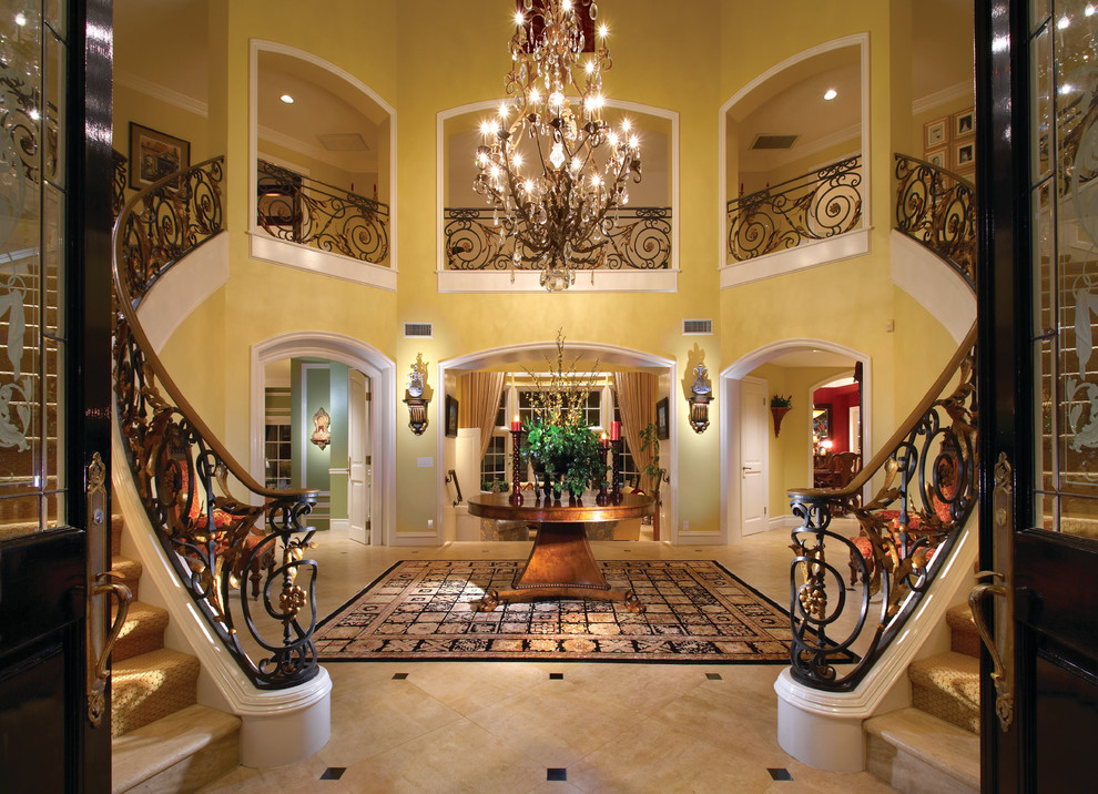 This is an example of an expansive traditional foyer in Orange County with yellow walls and a double front door.
