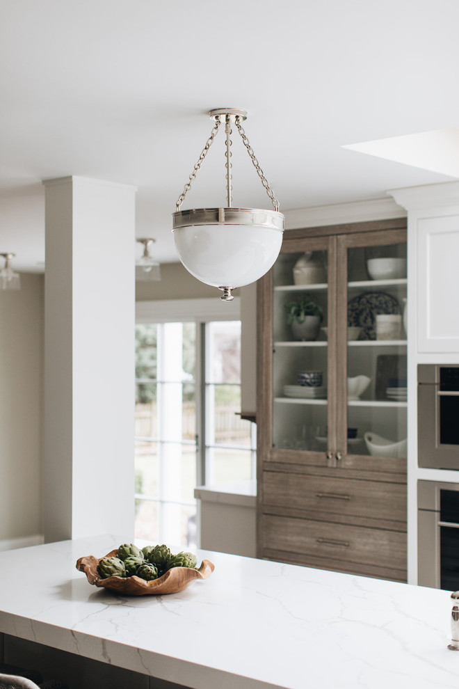 Eat-in kitchen - mid-sized transitional dark wood floor and brown floor eat-in kitchen idea in Chicago with a farmhouse sink, beaded inset cabinets, white cabinets, quartz countertops, paneled appliances, an island and white countertops