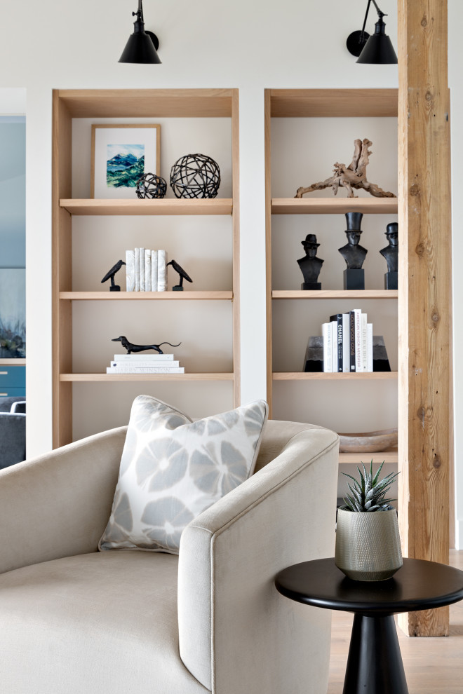 Modelo de biblioteca en casa abierta actual grande con paredes blancas, suelo de madera en tonos medios, suelo beige y vigas vistas