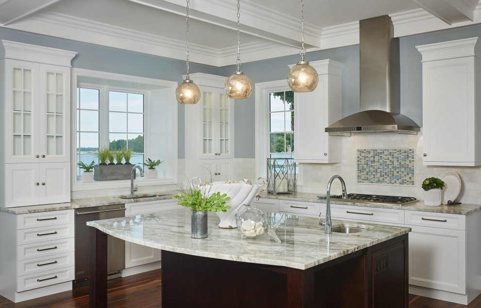 This is an example of a mid-sized beach style l-shaped kitchen in Grand Rapids with recessed-panel cabinets, white cabinets, granite benchtops, white splashback, mosaic tile splashback, stainless steel appliances, medium hardwood floors, with island, white benchtop and coffered.
