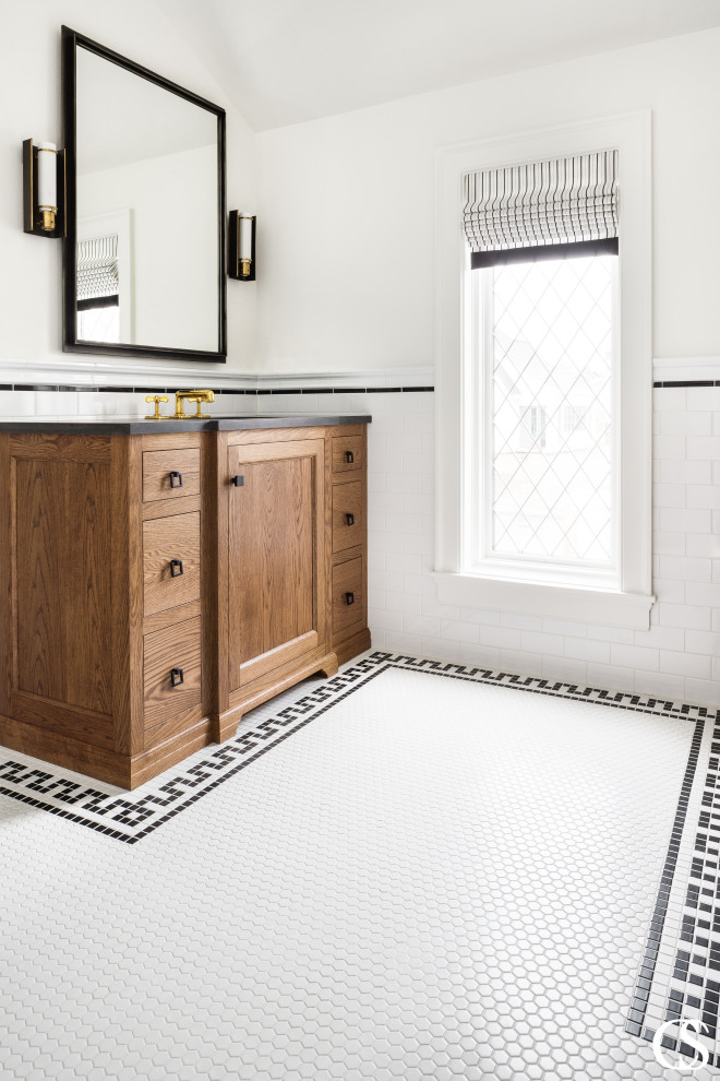 Aménagement d'une salle de bain classique en bois brun avec un carrelage blanc, un carrelage métro, un mur blanc, un sol en carrelage de terre cuite, un lavabo posé, un sol blanc, un plan de toilette noir, meuble simple vasque et meuble-lavabo sur pied.