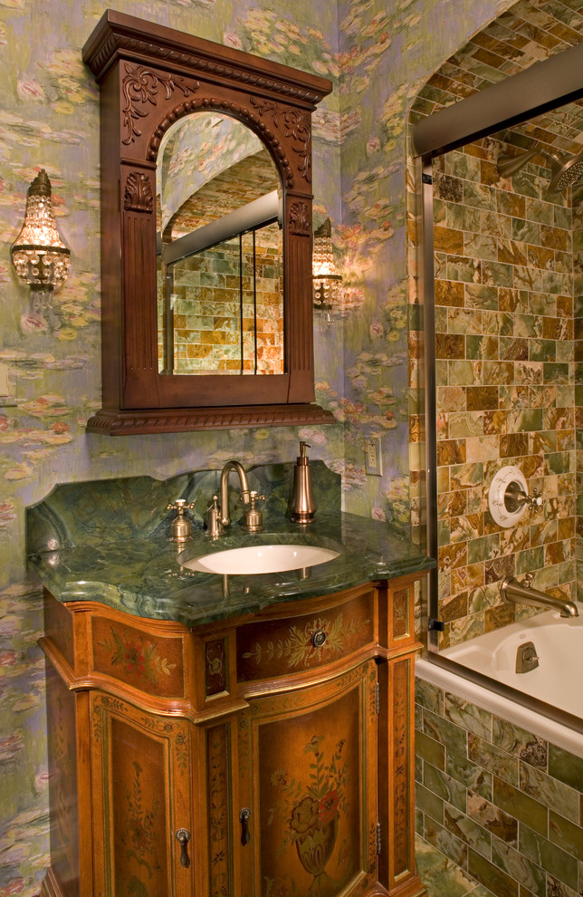 This is an example of a mid-sized traditional 3/4 bathroom in Chicago with an undermount sink, medium wood cabinets, an alcove tub, a shower/bathtub combo, green tile, purple walls, furniture-like cabinets, stone tile, slate floors, marble benchtops, green floor, a sliding shower screen and green benchtops.
