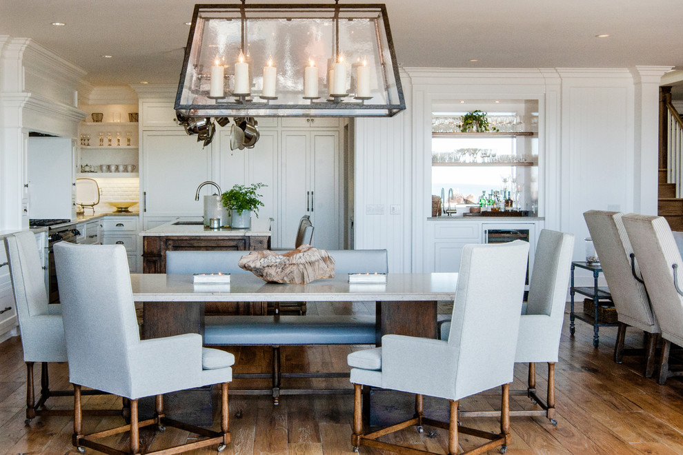 This is an example of a beach style open plan dining in Orange County with white walls and medium hardwood floors.