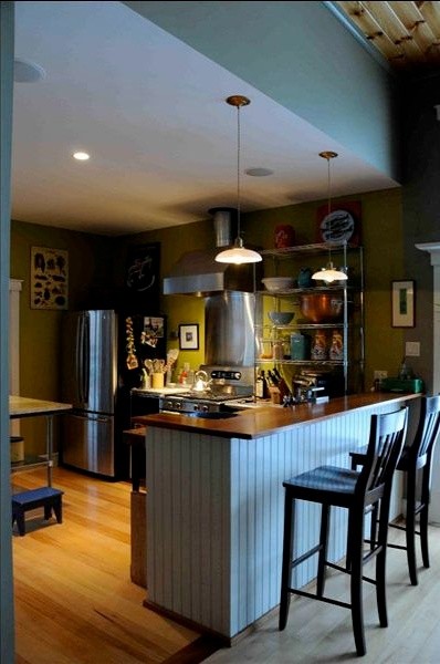 Design ideas for an eclectic kitchen in Burlington with stainless steel appliances, light hardwood floors and with island.