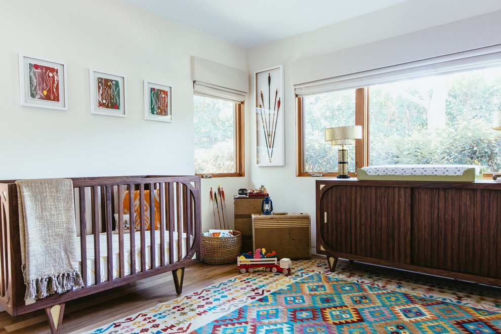 Mittelgroßes, Neutrales Retro Babyzimmer mit weißer Wandfarbe und braunem Holzboden in Los Angeles