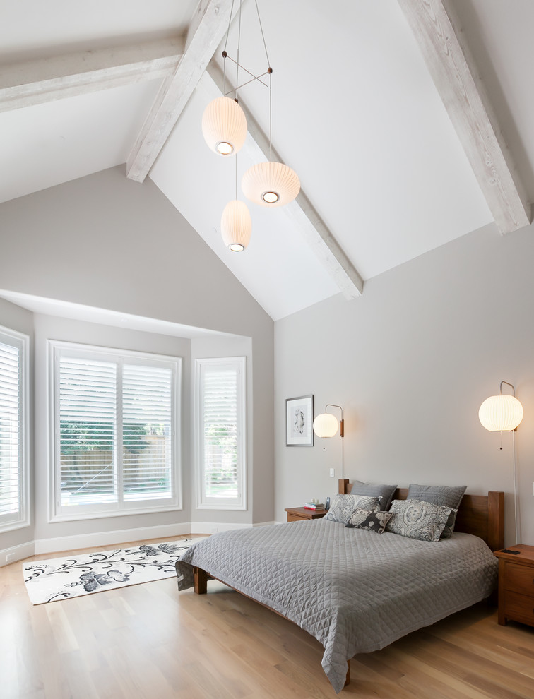Design ideas for a large scandinavian master bedroom in Houston with grey walls and light hardwood floors.