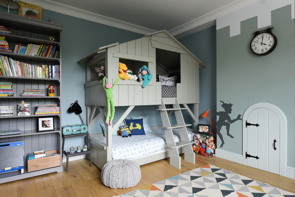 This is an example of a mid-sized transitional kids' room for boys in London with grey walls and light hardwood floors.