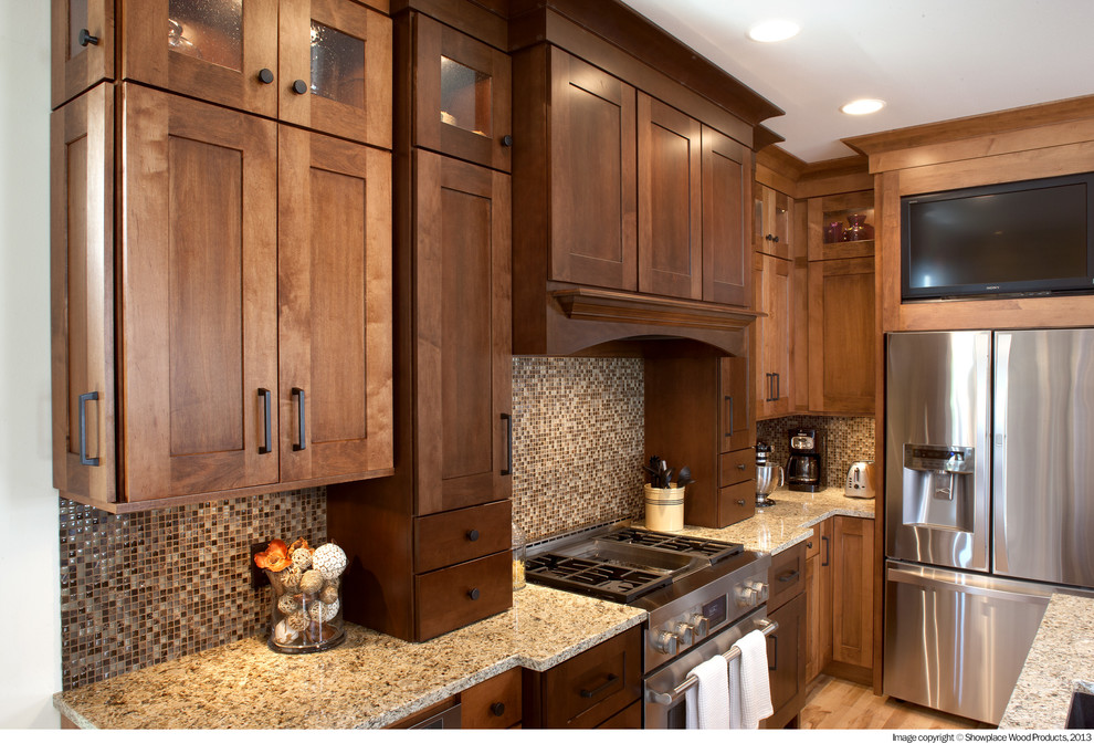 Inspiration for a rustic light wood floor and beige floor kitchen remodel with an undermount sink, shaker cabinets, dark wood cabinets, granite countertops, multicolored backsplash, mosaic tile backsplash, stainless steel appliances and an island