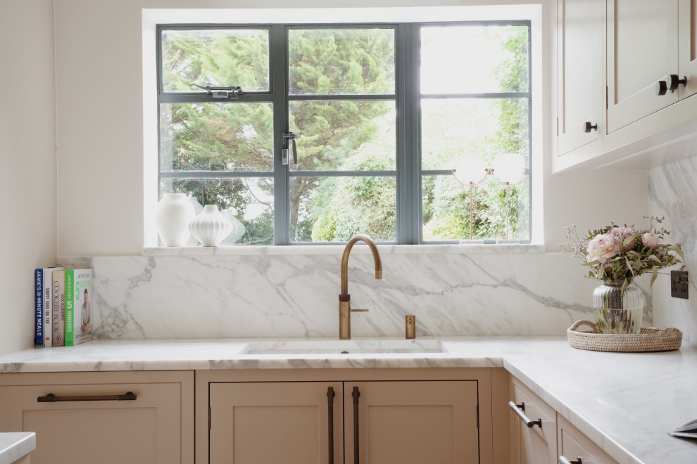 This is an example of a medium sized traditional l-shaped kitchen in London with a submerged sink, shaker cabinets, pink cabinets, quartz worktops, white splashback, an island and white worktops.