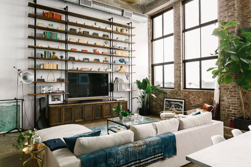 Design ideas for an industrial open concept family room in Other with white walls, concrete floors, a wall-mounted tv and grey floor.