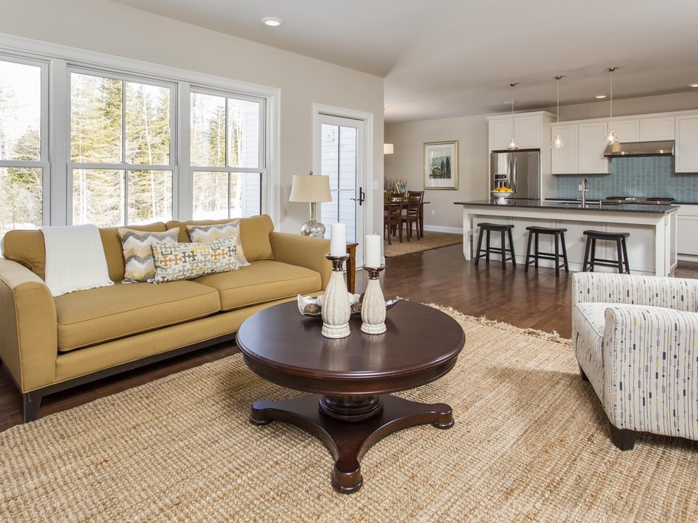 Photo of a mid-sized transitional open concept living room in Portland Maine with beige walls, medium hardwood floors, a standard fireplace, a tile fireplace surround and a freestanding tv.