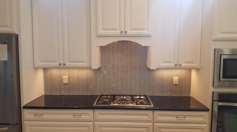 Inspiration for a mid-sized transitional single-wall eat-in kitchen remodel in Orlando with raised-panel cabinets, white cabinets, quartzite countertops, gray backsplash, glass tile backsplash, stainless steel appliances and no island
