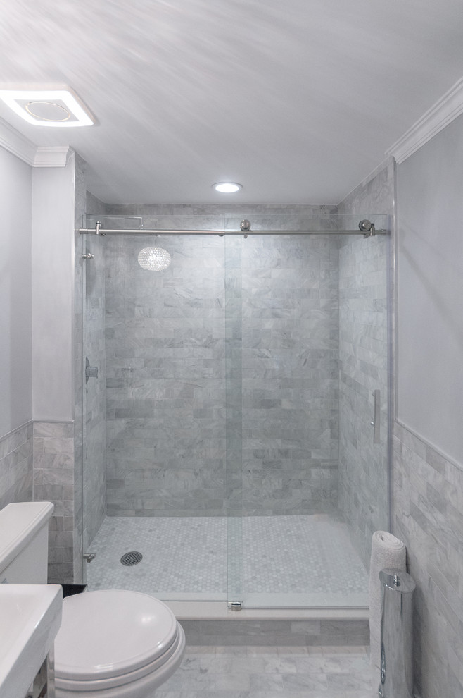 Inspiration for a mid-sized transitional 3/4 bathroom in Miami with a console sink, raised-panel cabinets, white cabinets, marble benchtops, an alcove shower, a two-piece toilet, gray tile, subway tile, grey walls and marble floors.