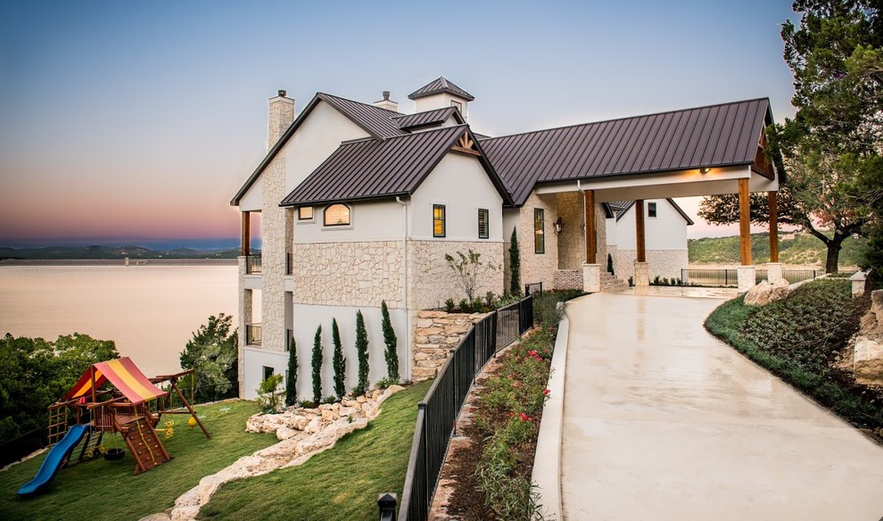 Design ideas for a country beige exterior in Houston with stone veneer and a gable roof.