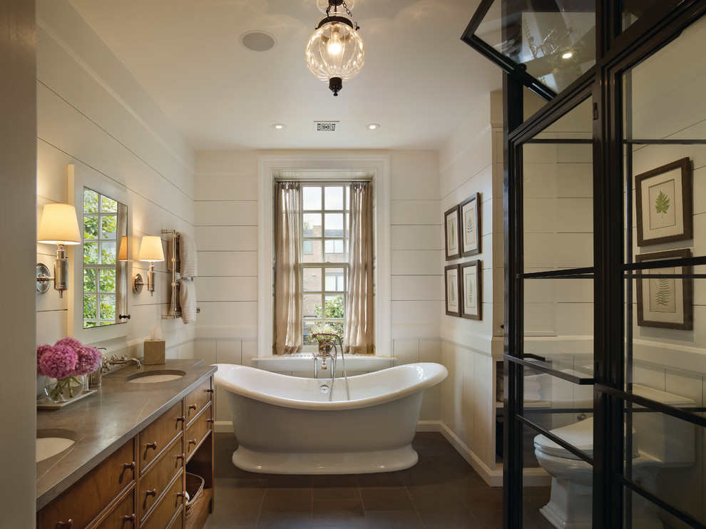 Design ideas for a traditional master bathroom in Philadelphia with medium wood cabinets, a freestanding tub, white walls, an undermount sink and flat-panel cabinets.