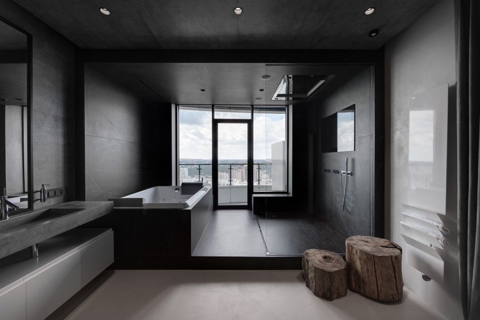 Idéer för mellanstora industriella grått badrum med dusch, med släta luckor, vita skåp, en jacuzzi, en kantlös dusch, grå kakel, stenhäll, grå väggar, klinkergolv i keramik, ett integrerad handfat, granitbänkskiva, grått golv och med dusch som är öppen
