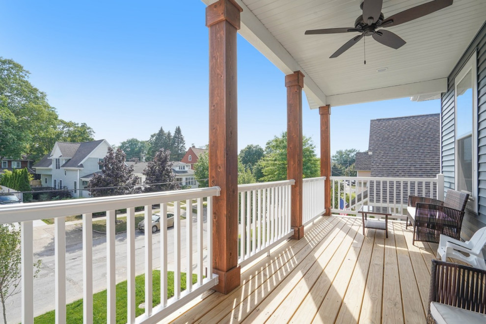 Photo of a large classic front metal railing veranda in Grand Rapids with with columns, decking and a roof extension.