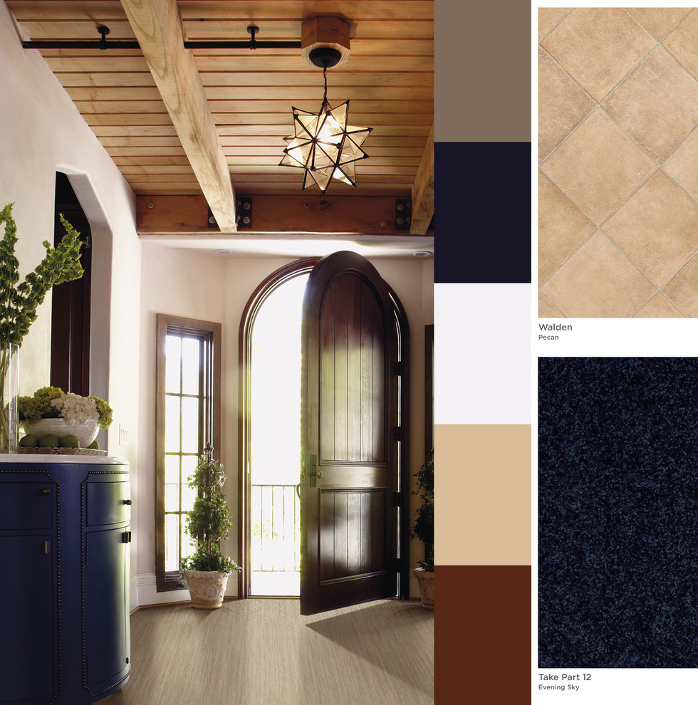 Example of a huge transitional foyer design with beige walls and a dark wood front door