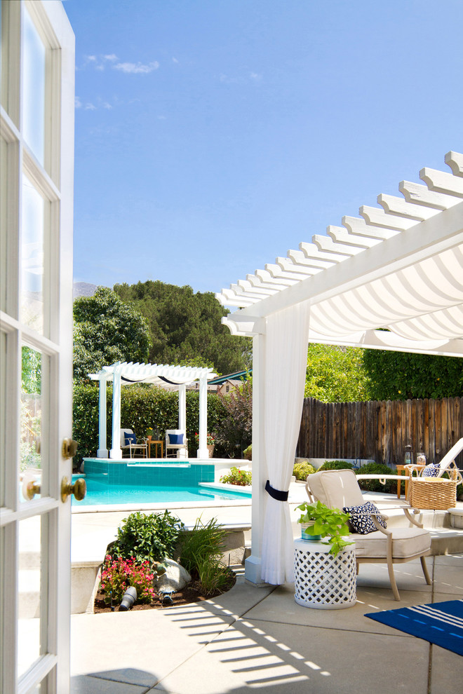 Design ideas for a large beach style backyard patio in Los Angeles with stamped concrete and a pergola.