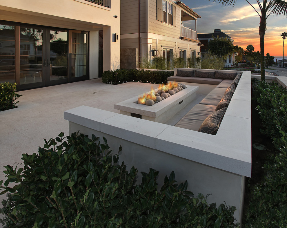 Large contemporary courtyard patio in Orange County with a fire feature, concrete slab and no cover.