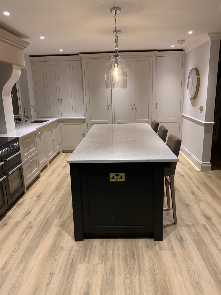 Photo of a mid-sized contemporary l-shaped kitchen in Surrey with beaded inset cabinets, quartzite benchtops, mirror splashback, with island and white benchtop.