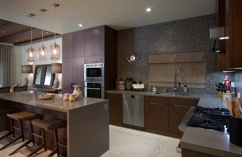 This is an example of a contemporary l-shaped eat-in kitchen in San Diego with a double-bowl sink, flat-panel cabinets, dark wood cabinets, grey splashback, mosaic tile splashback and stainless steel appliances.