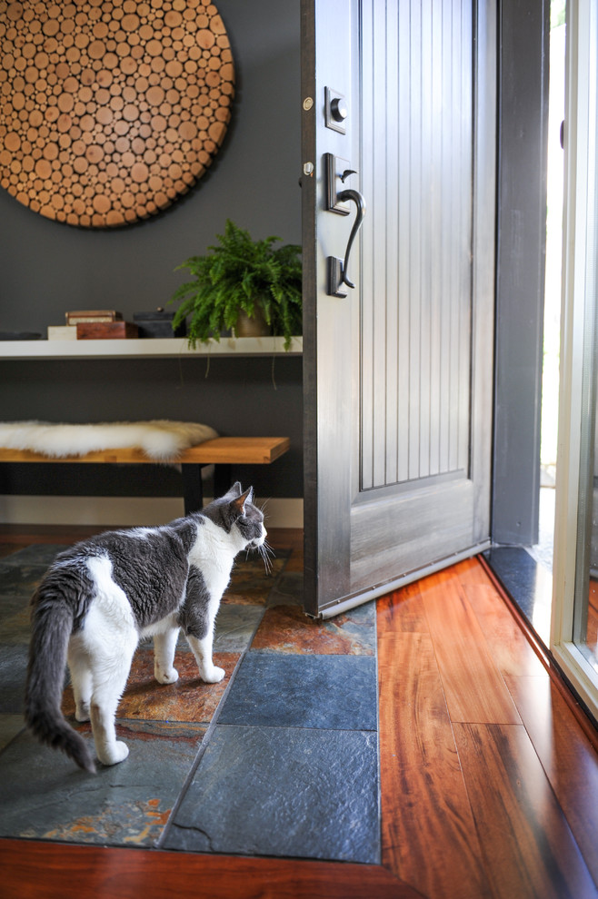 This is an example of a mid-sized beach style front door in Vancouver with white walls, medium hardwood floors, a single front door and a brown front door.