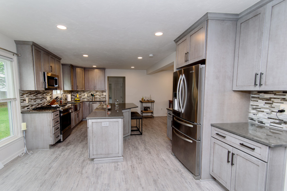 Example of a large transitional u-shaped gray floor eat-in kitchen design in Baltimore with a farmhouse sink, shaker cabinets, gray cabinets, quartz countertops, multicolored backsplash, glass tile backsplash, stainless steel appliances, an island and gray countertops