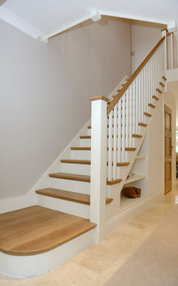 Inspiration for a large traditional wood straight staircase in London with wood risers and wood railing.
