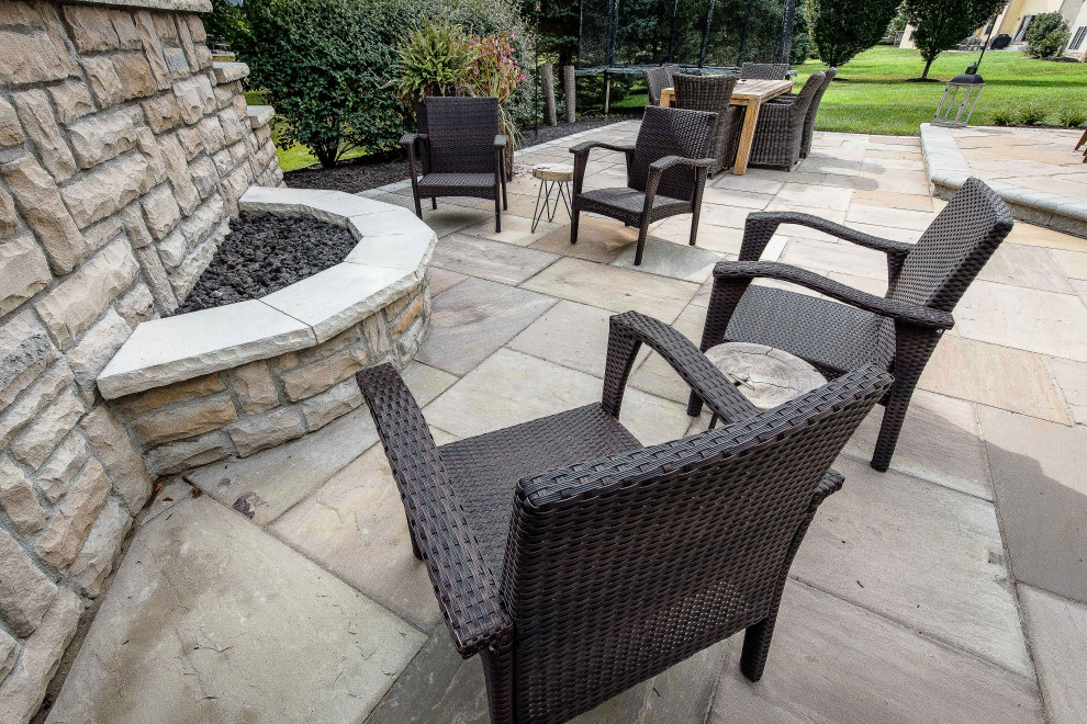 Example of a large classic backyard concrete paver patio design in Columbus with a fireplace