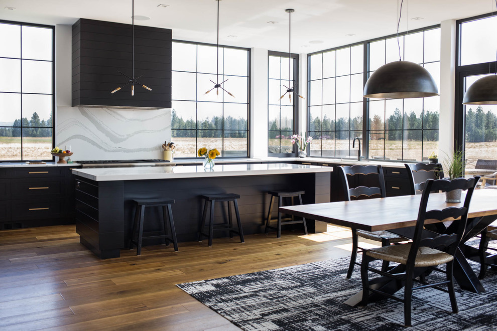 Design ideas for a large contemporary eat-in kitchen in Seattle with an undermount sink, recessed-panel cabinets, black cabinets, marble benchtops, white splashback, marble splashback, stainless steel appliances, medium hardwood floors, with island, white benchtop and brown floor.