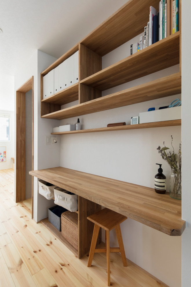 Идея дизайна: кабинет в скандинавском стиле с местом для рукоделия, белыми стенами, паркетным полом среднего тона и встроенным рабочим столом
