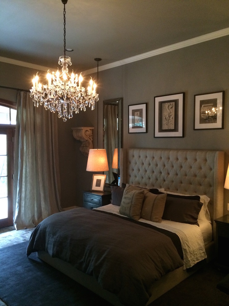 This is an example of a traditional master bedroom in Houston with grey walls and brick floors.