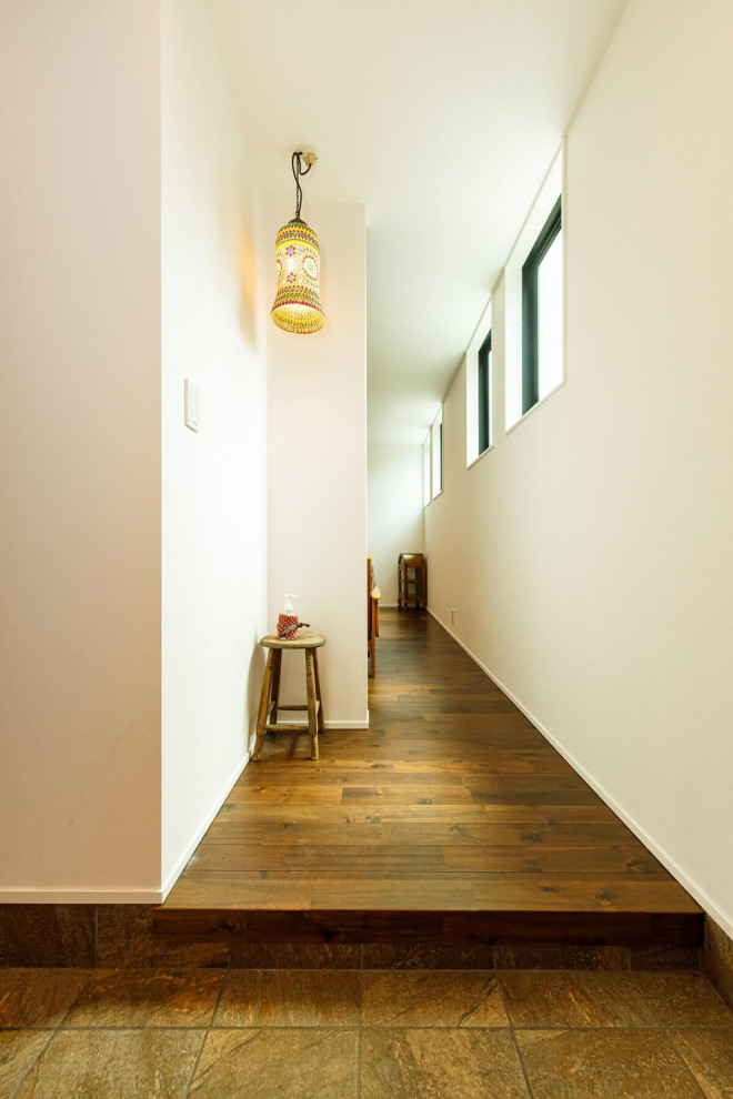 Imagen de hall blanco industrial de tamaño medio con paredes blancas, suelo de madera clara, suelo marrón, papel pintado y papel pintado