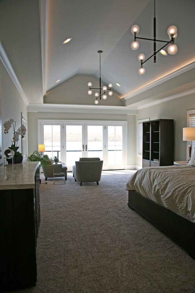 This is an example of a mid-sized contemporary master bedroom in Milwaukee with beige walls, carpet, beige floor and vaulted.