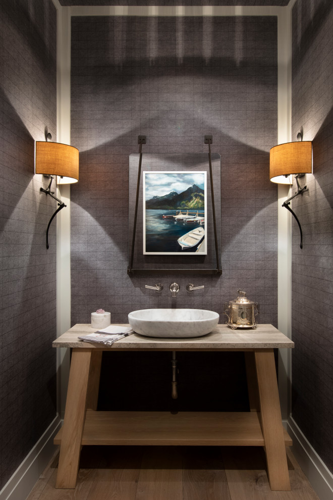Photo of a country powder room in Other with furniture-like cabinets, light wood cabinets, grey walls, medium hardwood floors, a vessel sink, brown floor and grey benchtops.