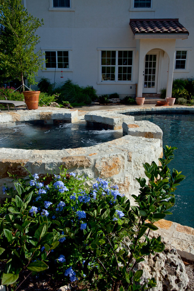 Inspiration for a mid-sized country backyard round aboveground pool in Austin with a water feature and stamped concrete.