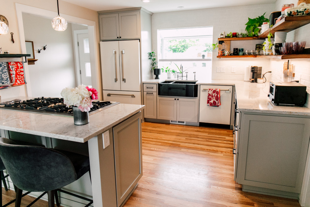 Photo of a small contemporary u-shaped eat-in kitchen in Seattle with a farmhouse sink, shaker cabinets, grey cabinets, quartz benchtops, white splashback, brick splashback, coloured appliances, medium hardwood floors, a peninsula, brown floor and yellow benchtop.