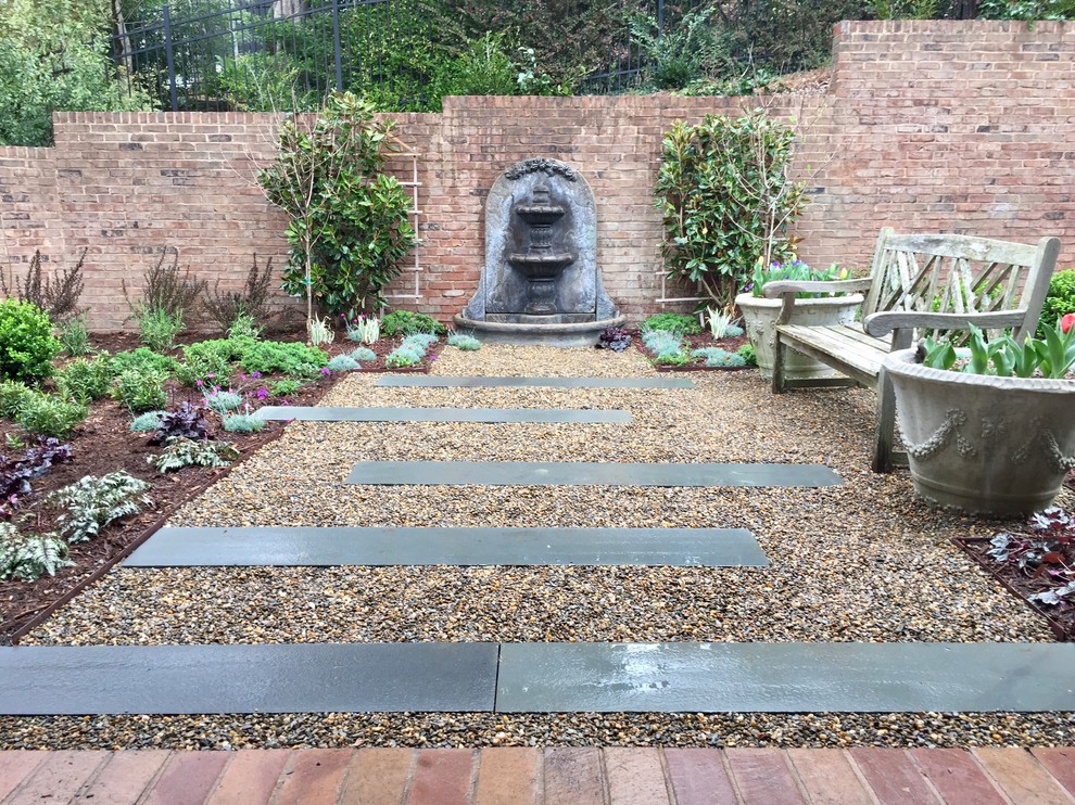 Inspiration for a small transitional courtyard patio in Charlotte with a water feature, gravel and no cover.