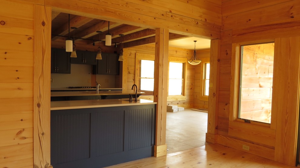Eat-in kitchen - mid-sized rustic u-shaped medium tone wood floor and brown floor eat-in kitchen idea with a drop-in sink, recessed-panel cabinets, blue cabinets, granite countertops, beige backsplash, mosaic tile backsplash, stainless steel appliances, an island and beige countertops