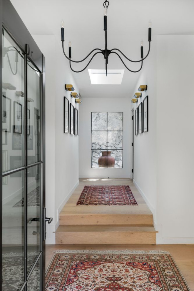 Ispirazione per un ingresso o corridoio minimal di medie dimensioni con pareti bianche e pavimento in legno massello medio