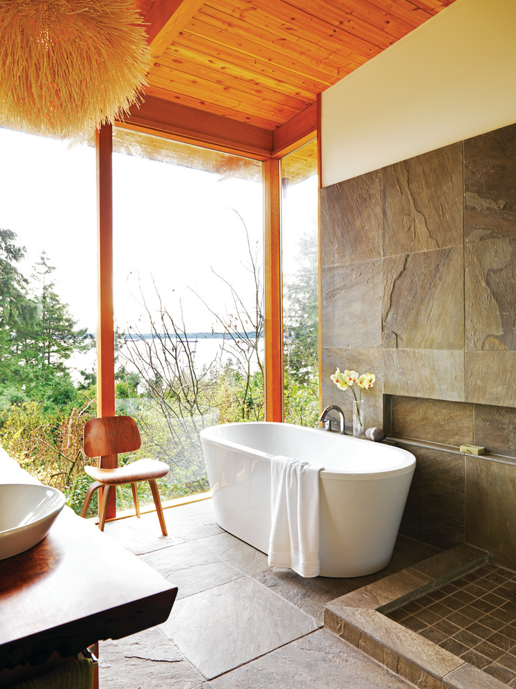 Photo of a country master bathroom in Vancouver with a freestanding tub and brown tile.