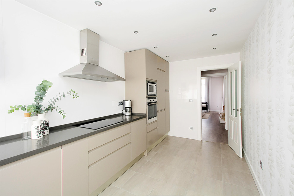 This is an example of a mid-sized scandinavian single-wall separate kitchen in Malaga with flat-panel cabinets, beige cabinets, white splashback and no island.