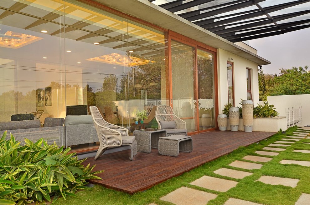 Photo of a contemporary backyard deck in Bengaluru with a pergola.