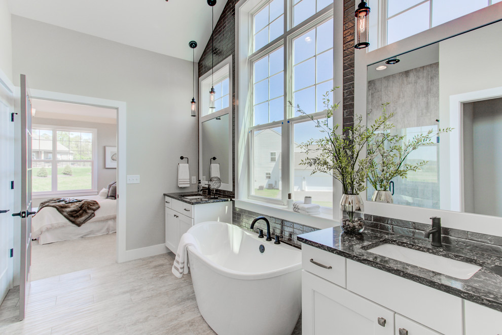 Inspiration for an expansive arts and crafts master bathroom in Other with white cabinets, a freestanding tub, an alcove shower, a two-piece toilet, black tile, beige walls, ceramic floors, an undermount sink, engineered quartz benchtops, a hinged shower door and black benchtops.