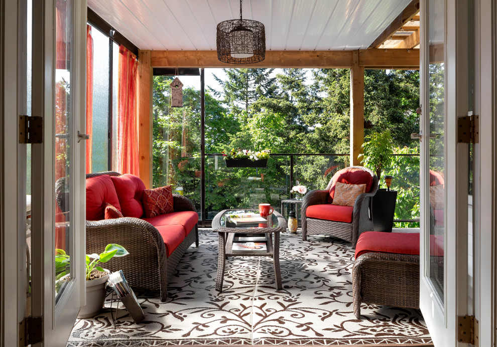 Inspiration for a transitional verandah in Vancouver with a roof extension and glass railing.