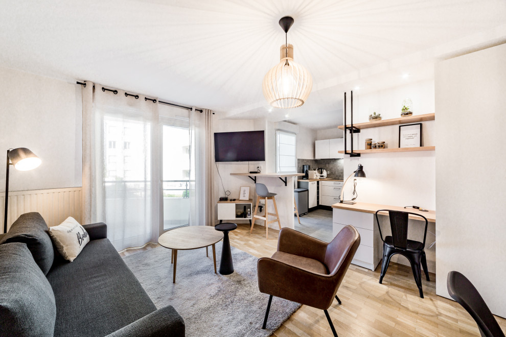 Foto de salón abierto nórdico grande sin chimenea con suelo de madera clara, paredes blancas, televisor colgado en la pared y suelo beige