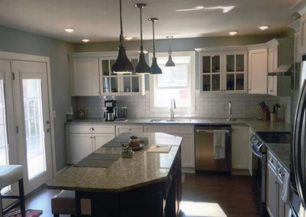 Large transitional l-shaped medium tone wood floor and brown floor eat-in kitchen photo with shaker cabinets, white cabinets, granite countertops, white backsplash, subway tile backsplash, stainless steel appliances, an island, beige countertops and an undermount sink